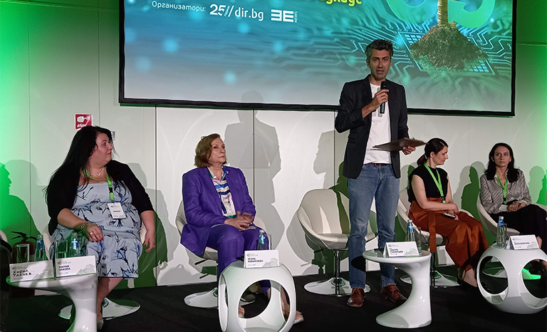 Участник в събитието GREEN WEEK 2023, говорещ по темата "Зелените иновации в строителния сектор и новият Европейски БАУХАУС". Около него седят и слушат други участници в събитието.